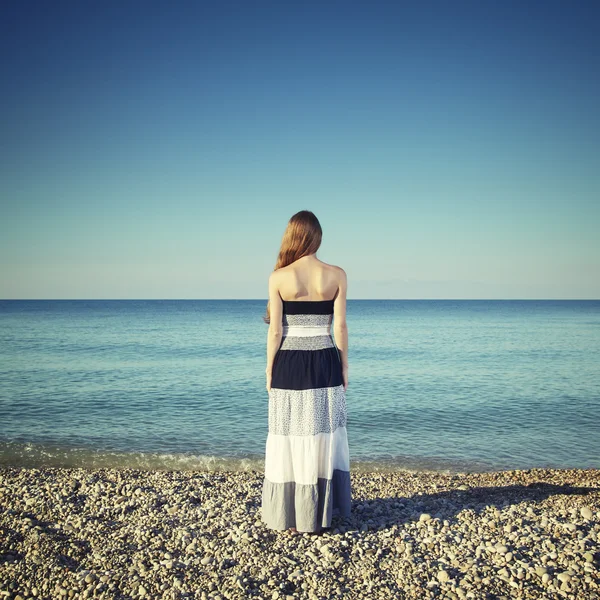 Hermosa mujer joven de pie en la playa — Foto de Stock
