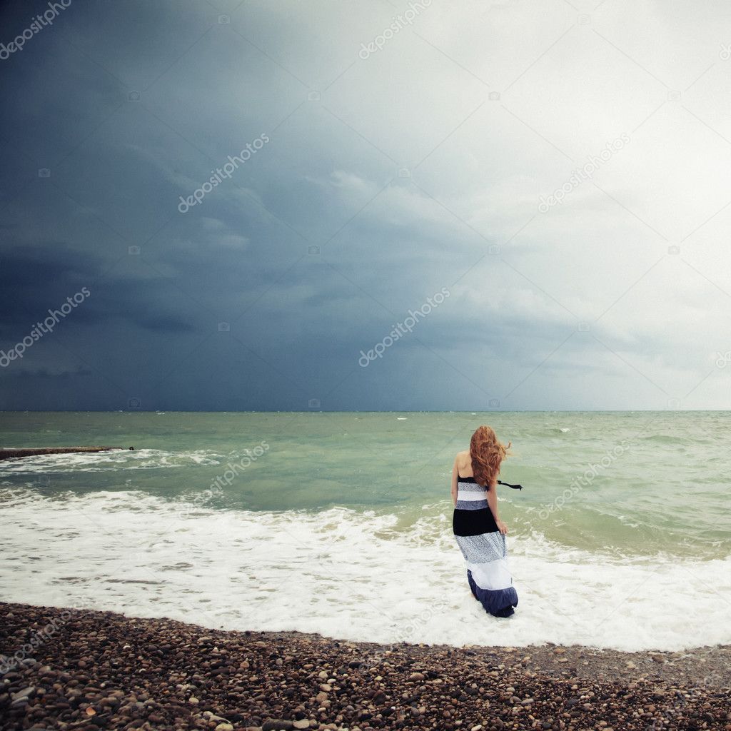The woman on the beach during a storm