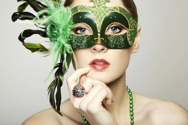 De mooie jonge vrouw in een groen Venetiaanse masker — Stockfoto
