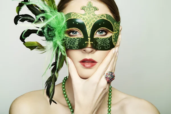 Die schöne junge Frau in einer grünen geheimnisvollen venezianischen Maske — Stockfoto