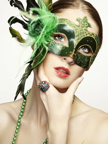 Die schöne junge Frau in einer grünen geheimnisvollen venezianischen Maske — Stockfoto