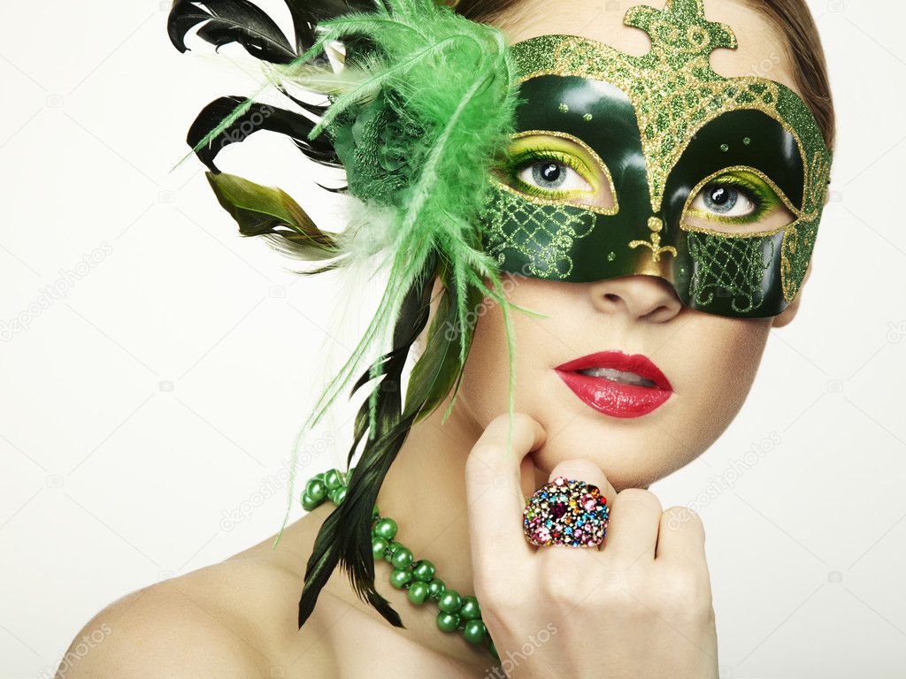 The beautiful young woman in a green mysterious venetian mask
