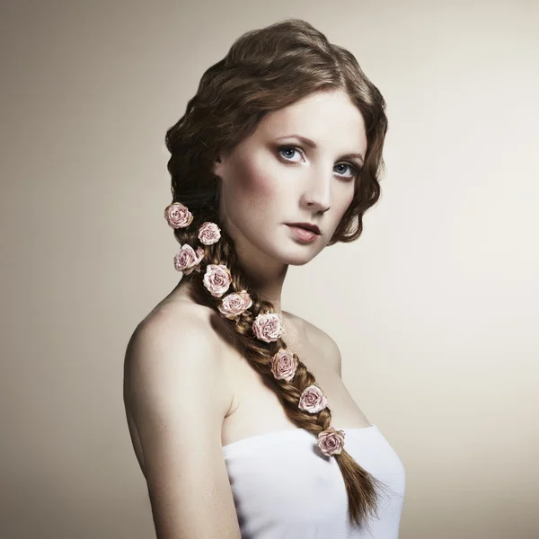 Retrato de uma mulher bonita com flores no cabelo — Fotografia de Stock