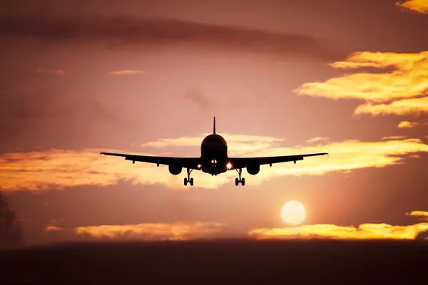 Avião no céu do pôr do sol — Fotografia de Stock
