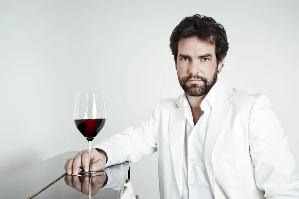 Yakışıklı bir adam ve bir kadeh kırmızı şarap — Stok fotoğraf