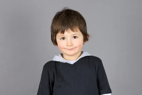 Bonito menino sorrir sobre cinza — Fotografia de Stock