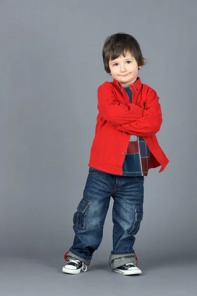 Cute little boy in red leaning — Stock Photo, Image