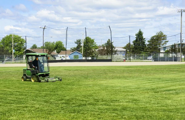 Cutting the grass of playing field — Stock Photo, Image