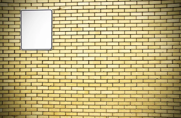 Parede de tijolo amarelo e sinal branco — Fotografia de Stock