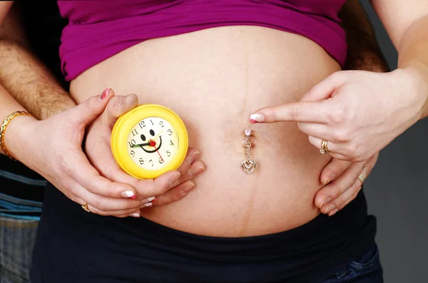 Těhotná pár s hodinami — Stock fotografie