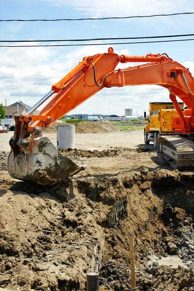 Excavadora mecánica naranja y agujero —  Fotos de Stock