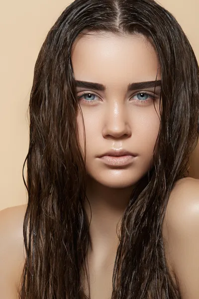 Vacker ung modell med långa våta hår, ljus makeup, starka ögonbryn och perfekt renhet hud. ny sommar look med fuktig strand frisyr — Stockfoto