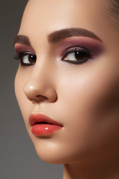 Portret uroda zbliżenie twarzy atrakcyjny model z jasnym Wizaż. fioletowy makijaż oczu i błyszczący makijaż usta — Zdjęcie stockowe