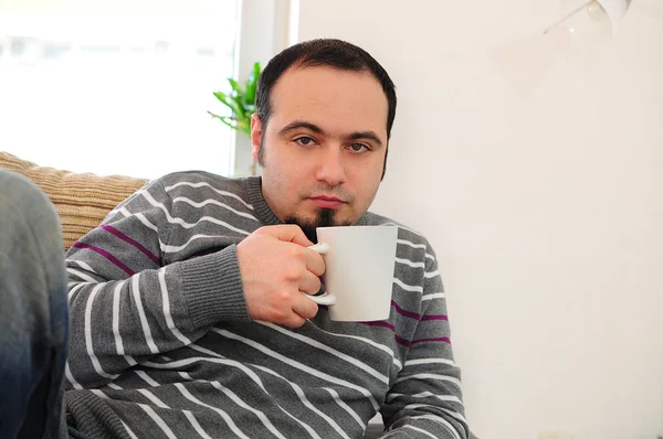 Jonge man met koffie of thee — Stockfoto