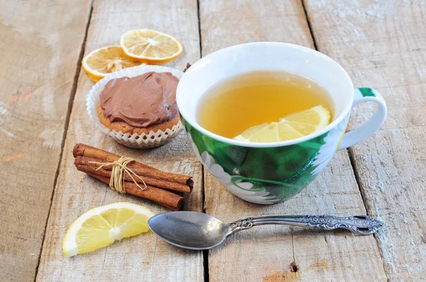Chá, cupcake, paus de canela e fatia de limão — Fotografia de Stock