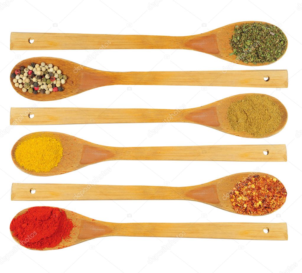 Various spices in wooden spoons isolated