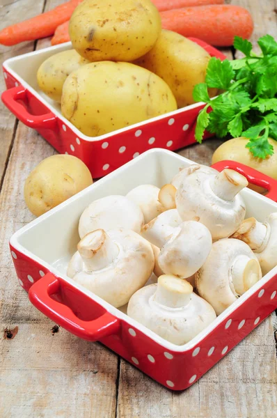 Surowe grzyby i ziemniaki w czerwony tacki — Zdjęcie stockowe