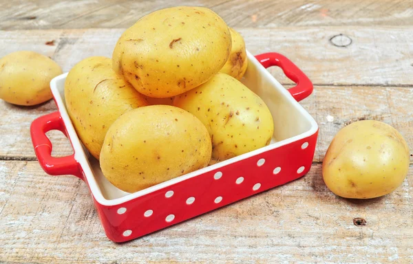 Raw potatoes in red tray — Stock Photo, Image