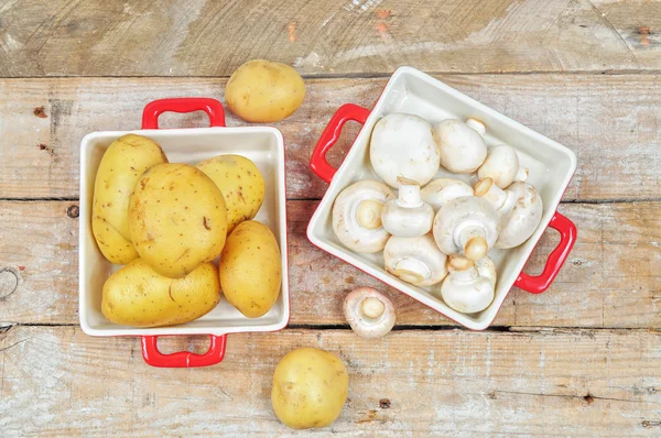 Surowe grzyby i ziemniaki w czerwony tacki — Zdjęcie stockowe