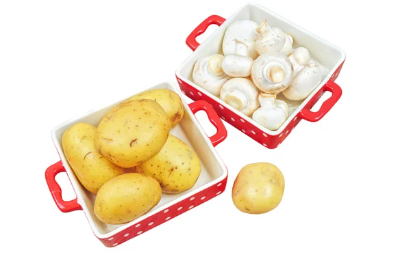Raw mushrooms and potatoes in red trays, isolated — Stock Photo, Image