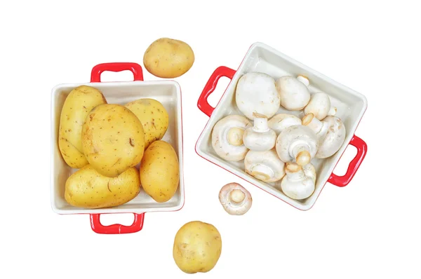 Rauwe paddestoelen en aardappelen in rode trays, geïsoleerd — Stockfoto