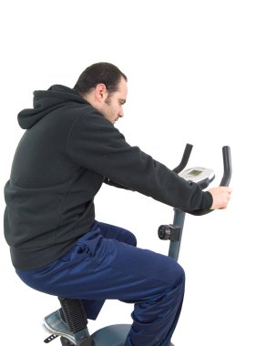 Young man on stationary training bicycle clipart