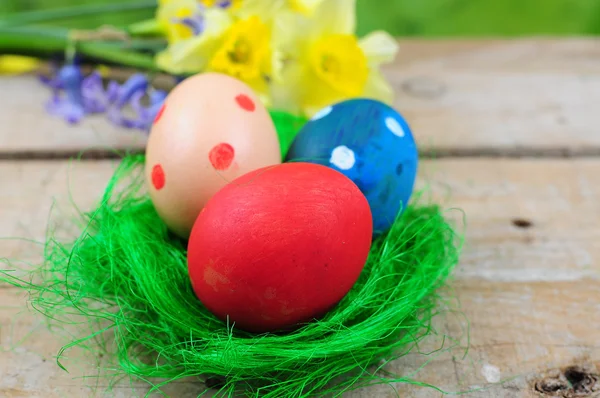 Three colorful easter eggs in green nest — Stock Photo, Image