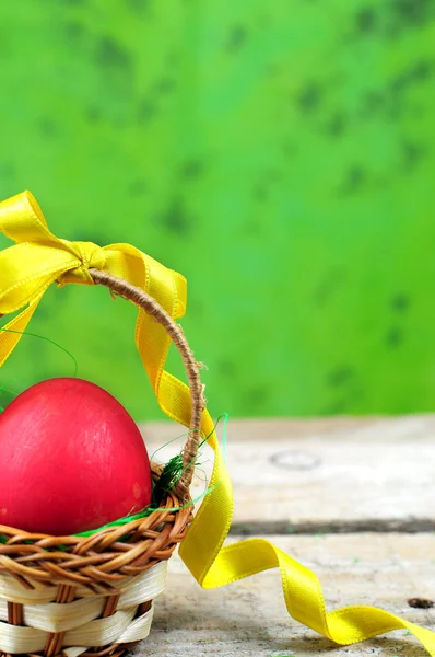 Red easter egg in basket with ribbon — Stock Photo, Image