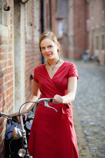 Гарненька молода жінка з велосипедом — стокове фото