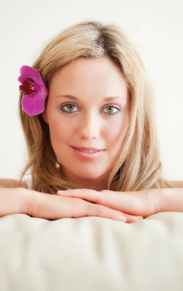 Pretty young woman with orchid in the hair — Stock Photo, Image