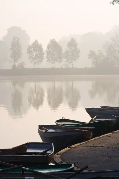 Rowing boats at misty pond — Stock Photo, Image