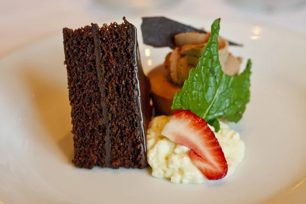 Ciasto czekoladowe z udekorować bitą śmietana truskawki i mięty — Zdjęcie stockowe