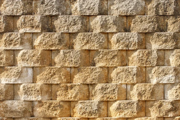 stock image Textured Interlocking Block Wall in Morning Light