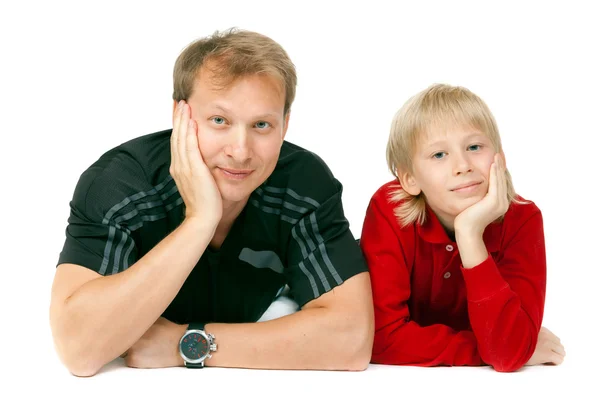 Dad and son lying on the floor in the studio — Stock Photo, Image