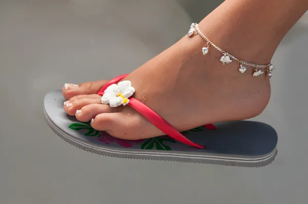 Women's leg with a bracelet in thong — Stock Photo, Image