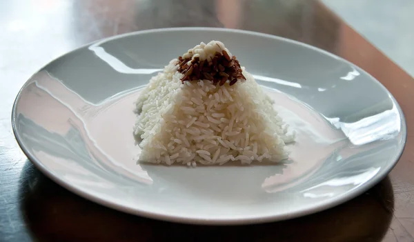 Pirâmide de arroz em uma placa em um restaurante com uma mesa desgastada — Fotografia de Stock