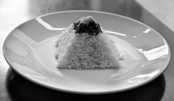 Pirâmide de arroz em uma placa em um restaurante com uma mesa desgastada — Fotografia de Stock