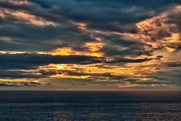 Západ slunce na zatažené moře — Stock fotografie