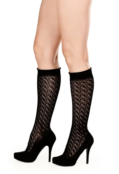 Vrouwelijke benen in fishnet sokken en schoenen — Stockfoto