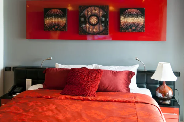 Красная кровать в отеле — стоковое фото