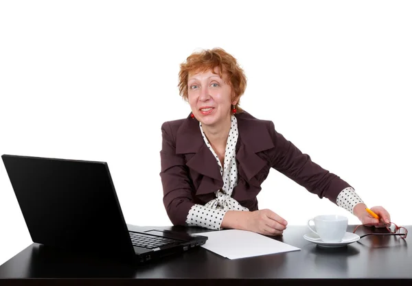 Orta yaşlı bir kadın masada, bir dizüstü bilgisayar — Stok fotoğraf