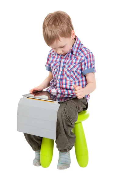 Мальчик с планшетным компьютером сидит на стуле — стоковое фото