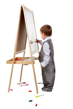 bir çocuk olarak stüdyonun bir şövale üzerinde boyar.