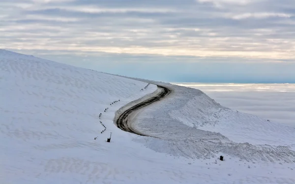 雪に覆われた山の未舗装の道路 — ストック写真
