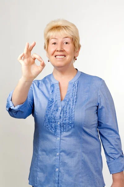 Kobieta w średnim wieku pokazuje ok — Zdjęcie stockowe