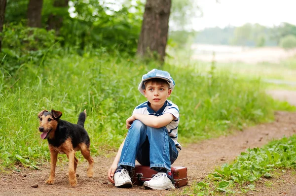 De jongen met zijn hond in het bos — Stockfoto