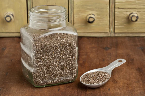 Jar and tablespoon of chia seeds — Stock Photo, Image