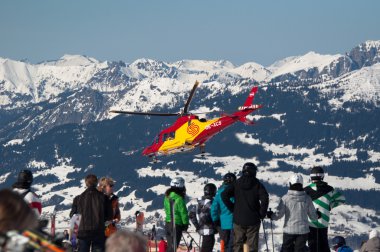 MONTAFON, AUSTRIA - FEBRUARY 29 : A helicopter is flying an injured skiier from the Montafon skiing area in Austria to the hospital in Bludenz on February 29, 2012 in Montafon, Austria. Many w clipart