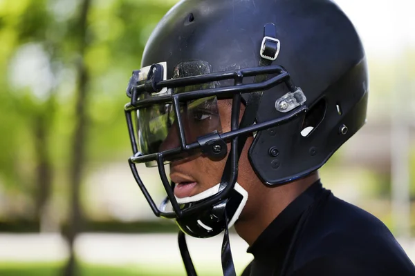 Profil ung svart man i fotboll hjälm — Stockfoto
