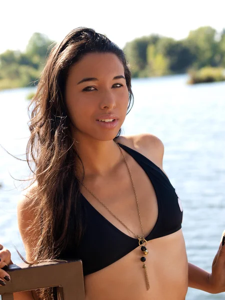 Young Hispanic Woman black bikini top river Stock Photo by
